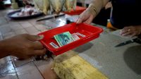 Pasar Tangguh di Surabaya Gunakan Nampan untuk Transaksi Jual Beli