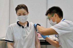 826-Petugas memvaksin seorang warga Jepang Jepang Hentikan Pemberian Vaksin Moderna Karena Tercemar Bahan Asing